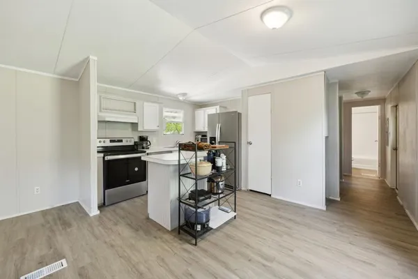 a kitchen with a refrigerator and a stove top oven