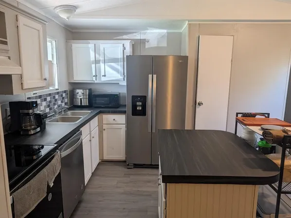 a kitchen with a refrigerator and a sink