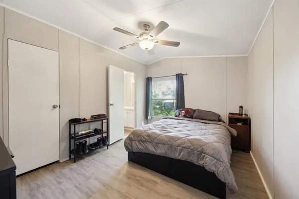 a bedroom with a bed and a ceiling fan