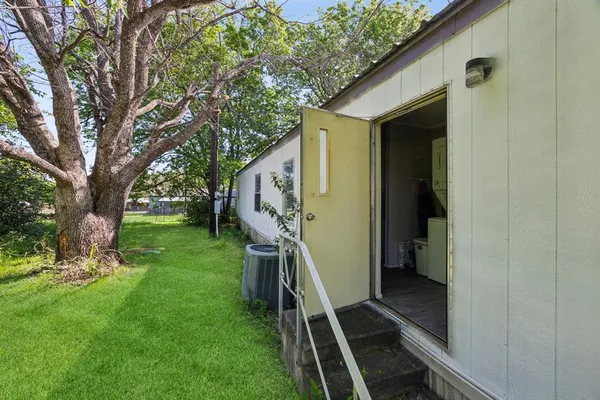 a view of a house with backyard and trees