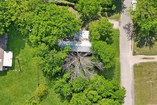 an aerial view of residential house with outdoor space and trees all around