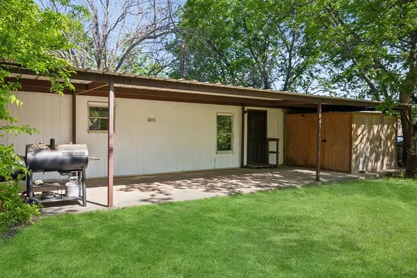 a backyard of a house with table and chairs