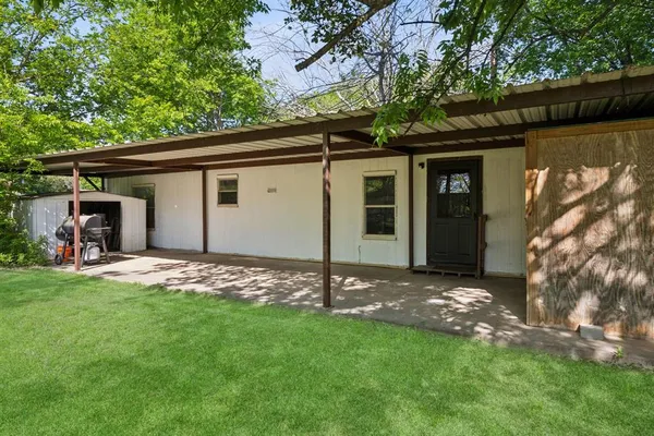a backyard of a house with table and chairs