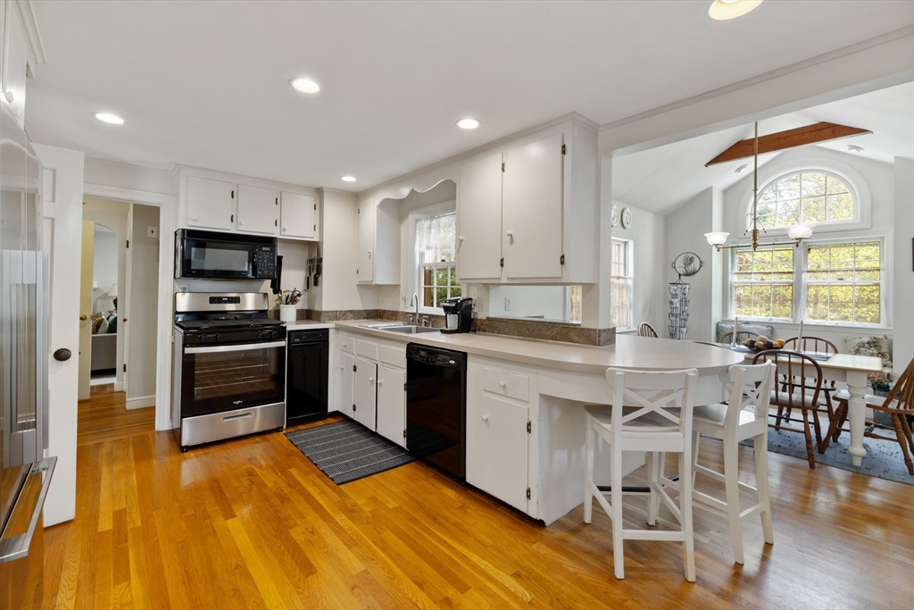 4 Longfellow Road Lexington, MA 02420 - Photo 2 of 37 a kitchen with granite countertop a stove top oven a sink dishwasher a dining table and chairs with wooden floor