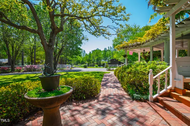 a dining hall with stainless steel appliances kitchen island granite countertop a table chairs and a chandelier