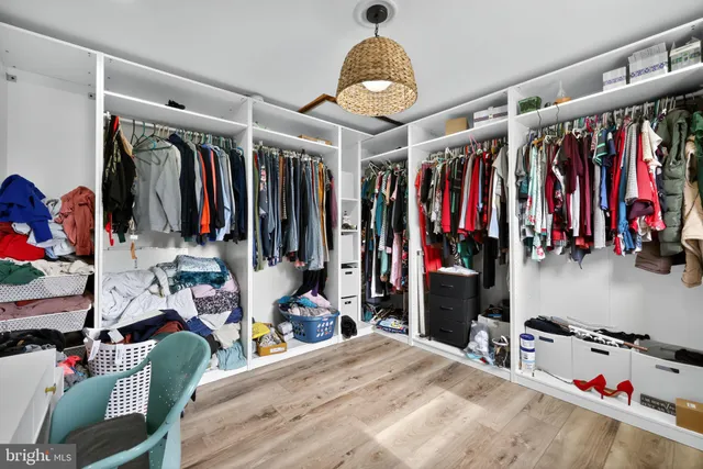 a view of walk in closet with clothes and shoes