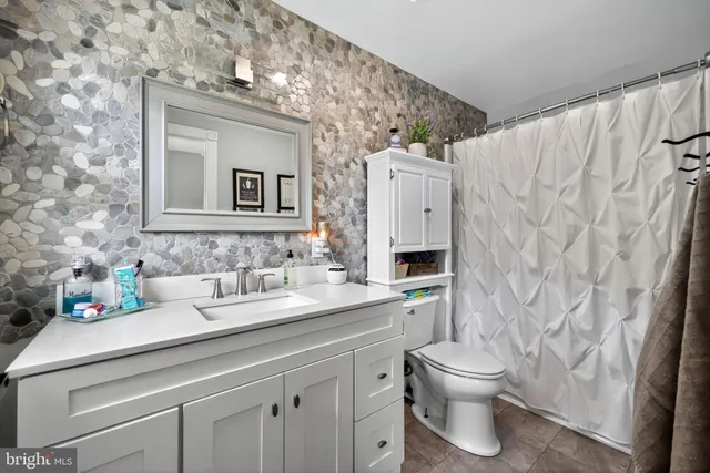 a bathroom with a toilet sink and mirror