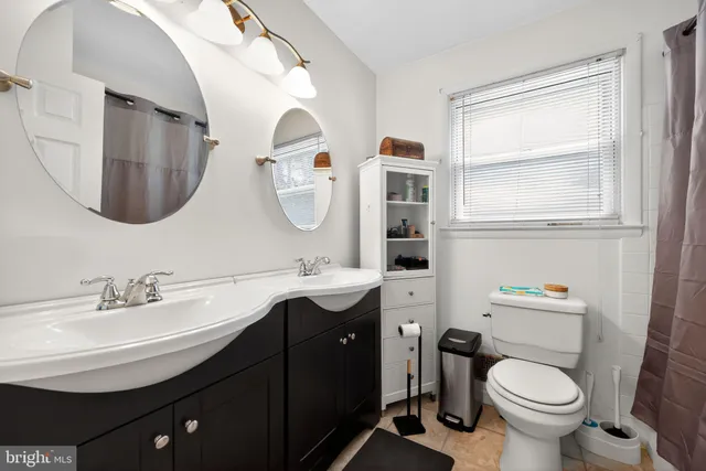 a bathroom with a toilet a sink and mirror