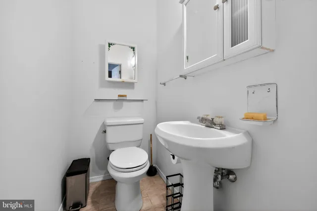 a bathroom with a toilet sink and mirror