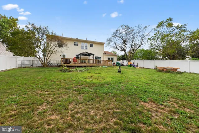 a view of a house with a big yard and large trees