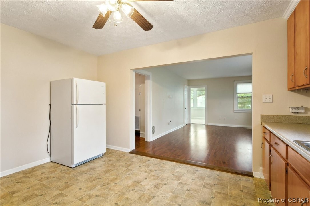 345 Fox Hill Road Hampton, VA 23669 - Photo 13 of 46 Kitchen with freestanding refrigerator, brown cabinetry, a ceiling fan, light countertops, and baseboards