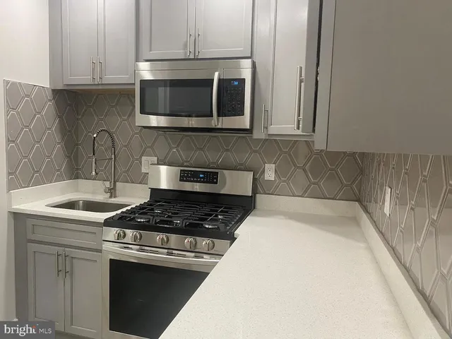 a kitchen with stainless steel appliances granite countertop a stove a microwave and cabinets