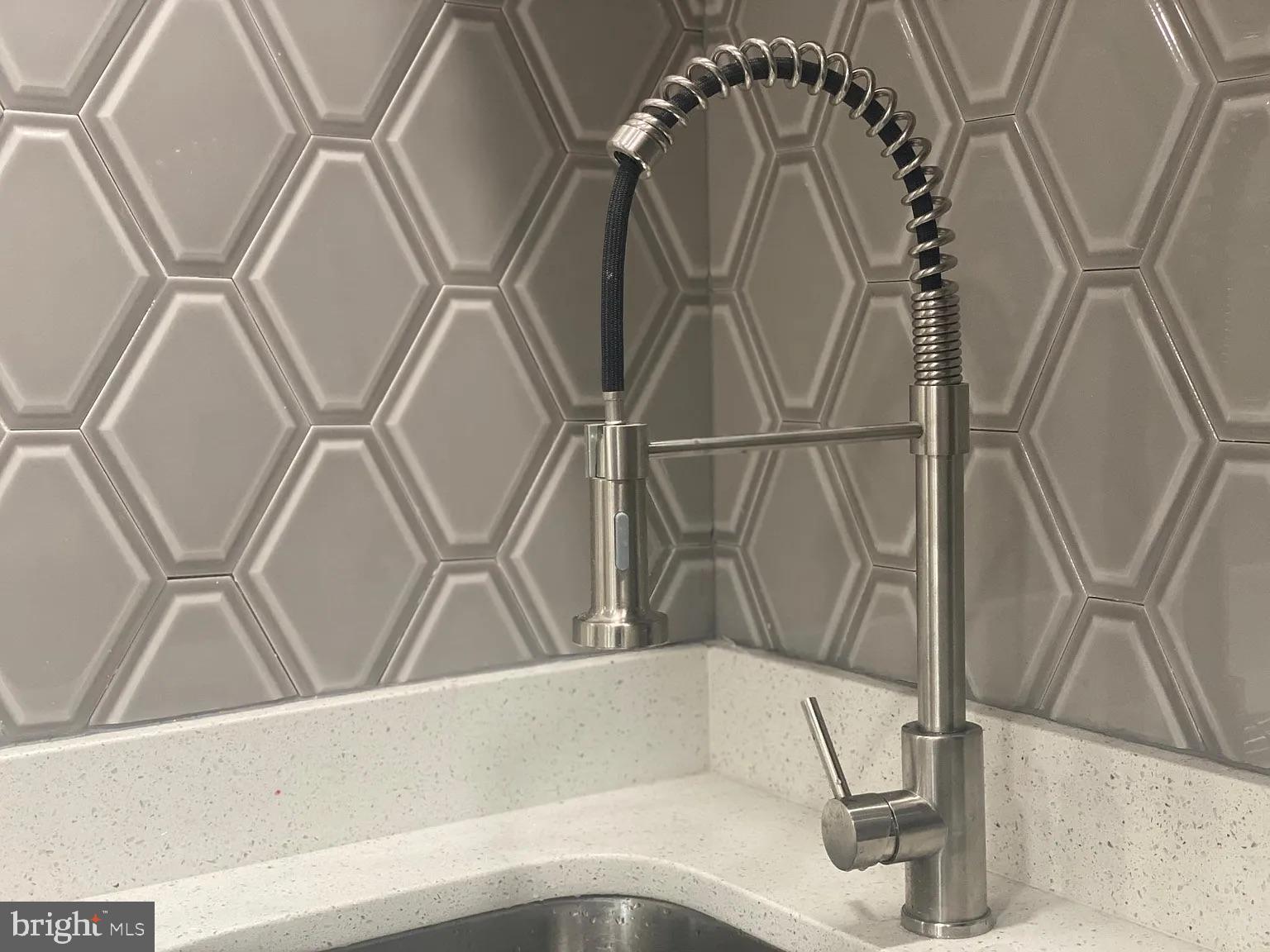 940 5th Street Laurel, MD 20707 - Photo 8 of 10 Sleek faucet against modern tile backdrop.