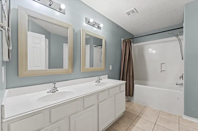 a bathroom with a tub a sink and mirror
