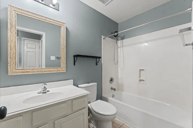 a bathroom with a sink toilet vanity and shower