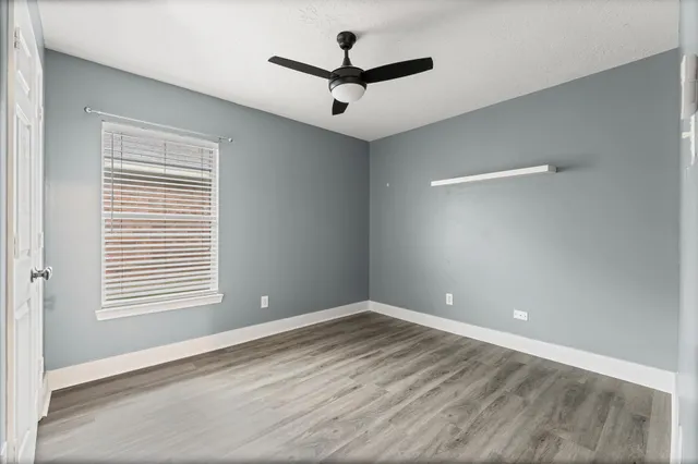 a view of empty room with ceiling fan and window