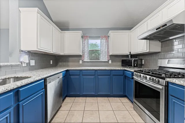 a kitchen with granite countertop a stove sink and cabinets