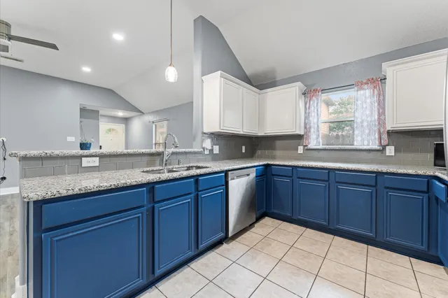 a kitchen with granite countertop a sink cabinets and window