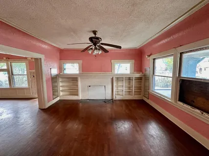 a view of empty room with wooden floor and fireplace