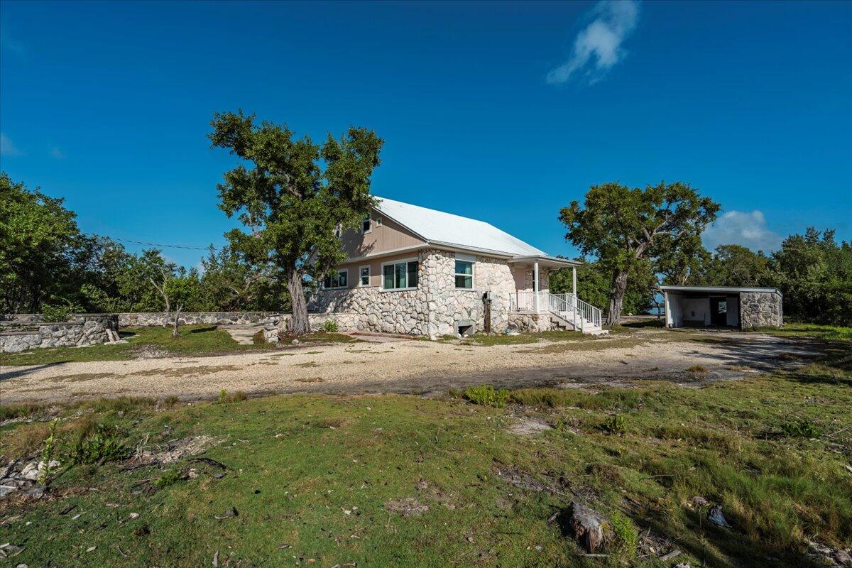 3167 Stewart Road Summerland Key, FL 33042 - Photo 9 of 33 a front view of a house with a yard and garage