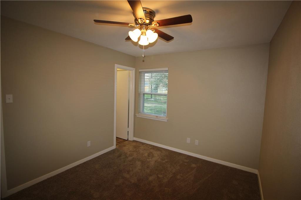 3532 Antilles Drive Mesquite, TX 75150 - Photo 12 of 18 an empty room with a chandelier fan and windows