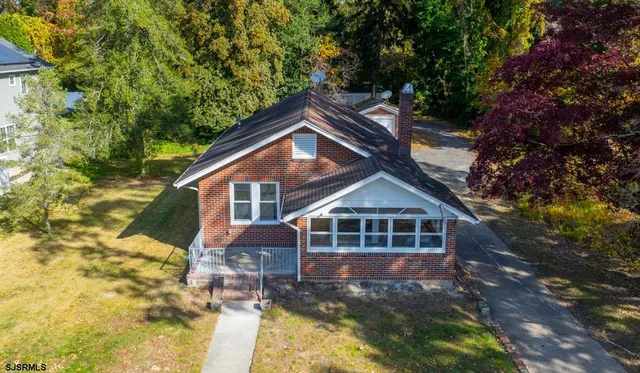 a front view of a house with yard and green space
