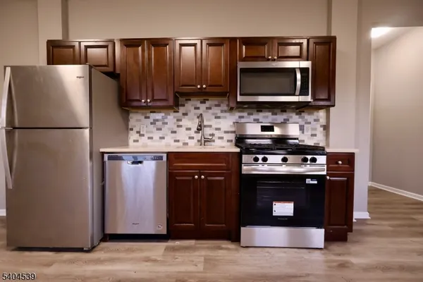 a kitchen with stainless steel appliances a stove a microwave and a refrigerator