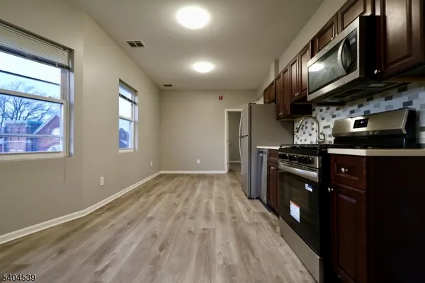 a kitchen with stainless steel appliances granite countertop a stove a sink and a microwave