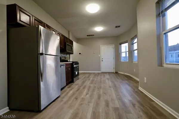 a kitchen with a refrigerator and a stove top oven