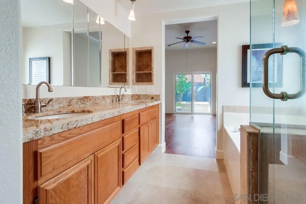 3924 Tortuga Cove Oceanside, CA 92058 - Photo 21 of 42 a spacious bathroom with a granite countertop sink and a mirror