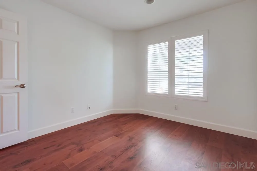 3924 Tortuga Cove Oceanside, CA 92058 - Photo 26 of 42 an empty room with wooden floor and windows