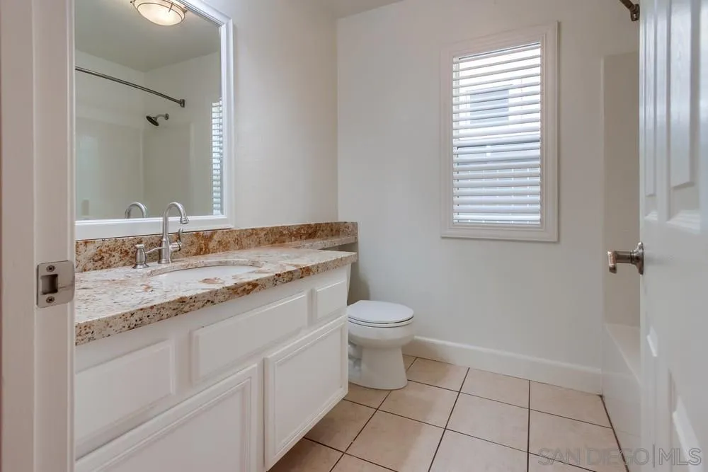 3924 Tortuga Cove Oceanside, CA 92058 - Photo 34 of 42 a bathroom with a granite countertop sink toilet and a mirror