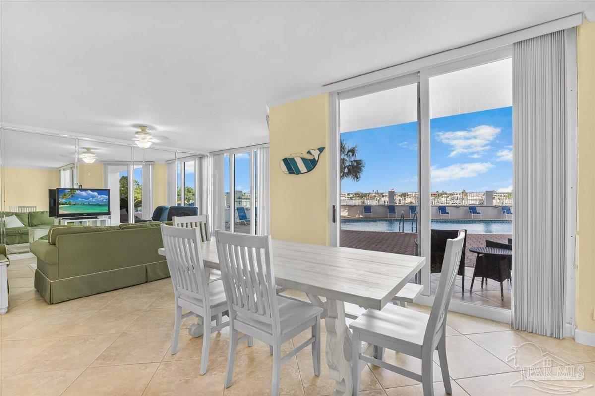 16284 Perdido Key Drive, Unit 112 Perdido Key, FL 32507 - Photo 18 of 37 a view of a dining room with furniture and a floor to ceiling window