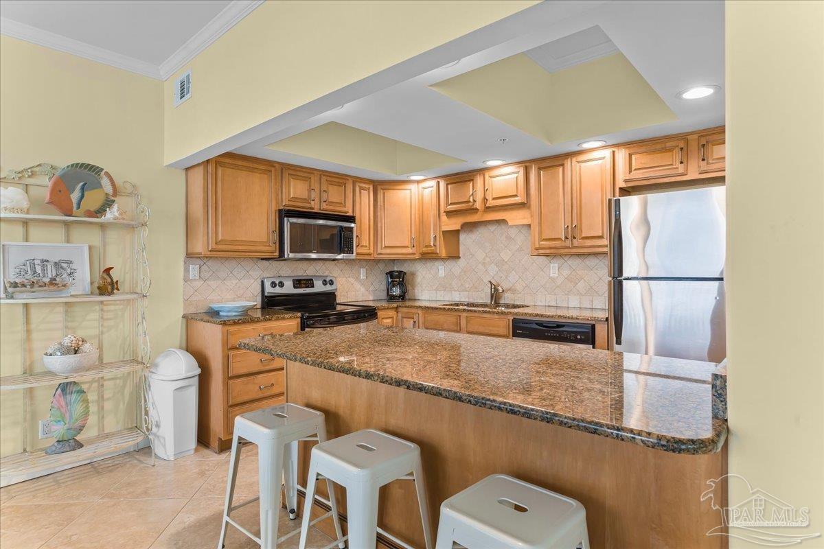 16284 Perdido Key Drive, Unit 112 Perdido Key, FL 32507 - Photo 20 of 37 a kitchen with stainless steel appliances granite countertop a sink stove refrigerator and microwave