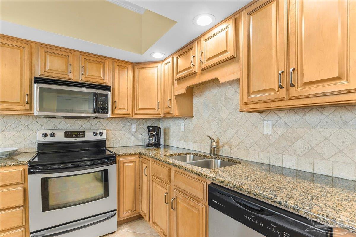 16284 Perdido Key Drive, Unit 112 Perdido Key, FL 32507 - Photo 22 of 37 a kitchen with stainless steel appliances granite countertop a sink and a stove