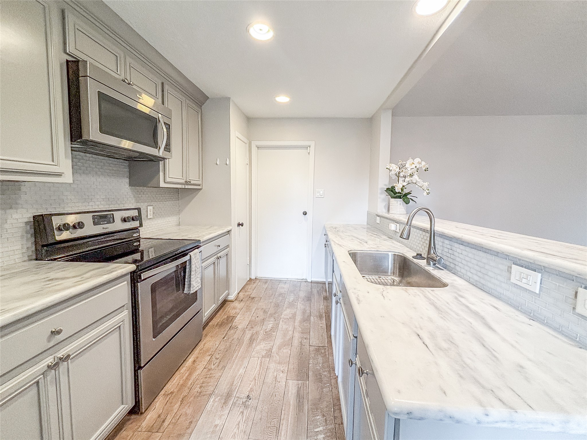3123 Lazy Spring Drive Houston, TX 77080 - Photo 9 of 24 a kitchen with stainless steel appliances granite countertop a sink a stove top oven a counter space and cabinets