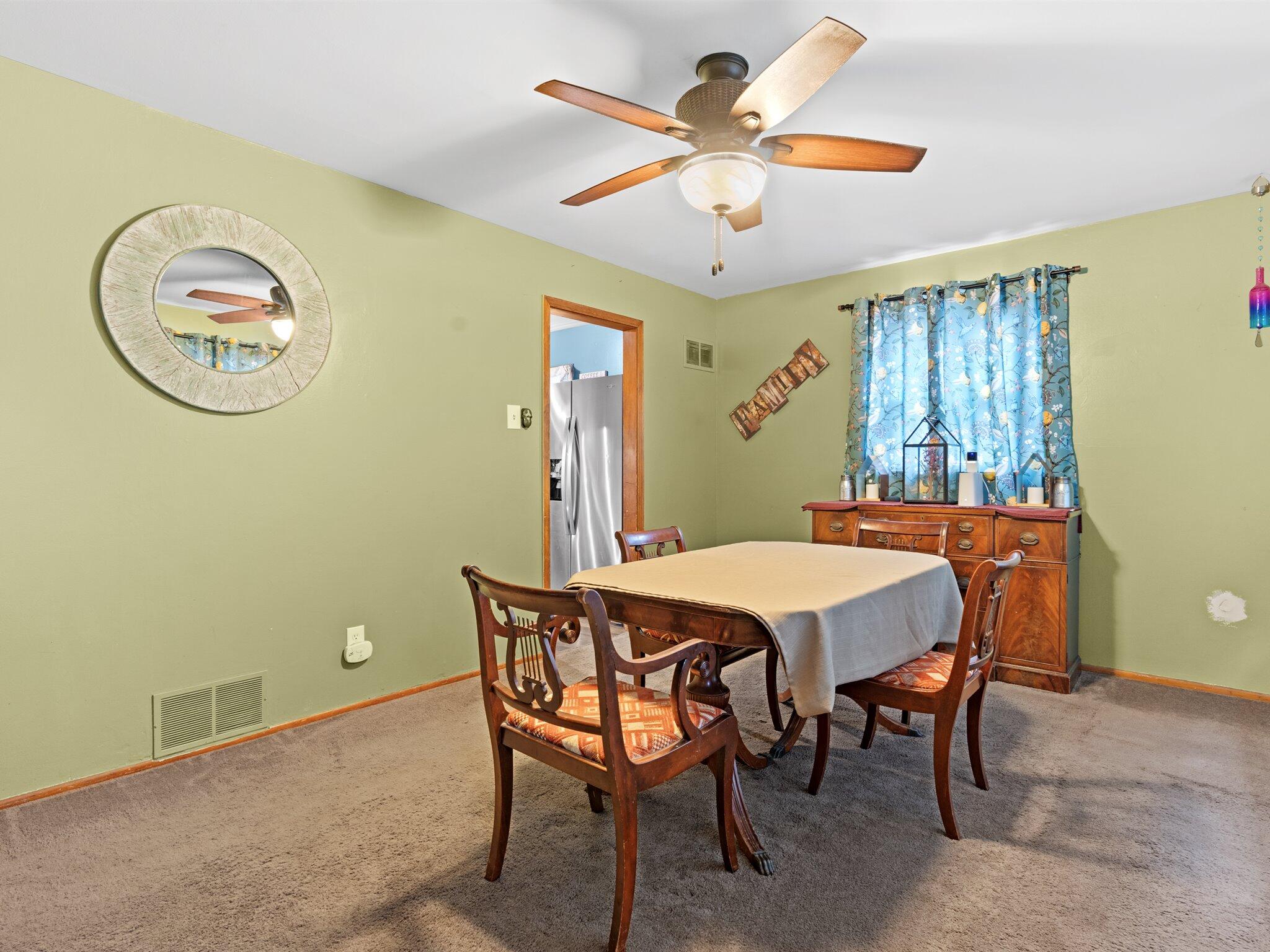 614 West Elm Street Griffith, IN 46319 - Photo 3 of 16 a dining room with a wooden table and a ceiling fan