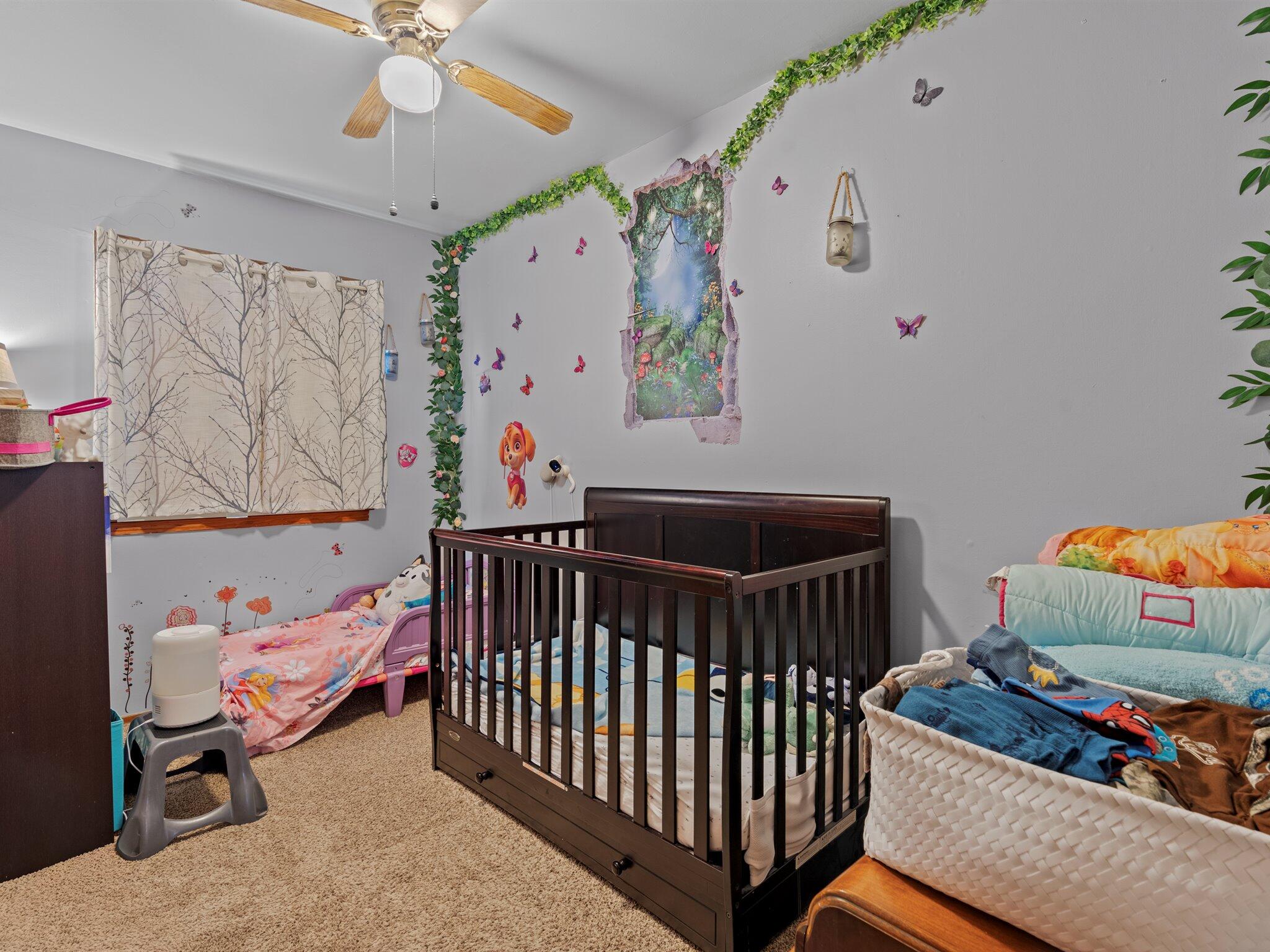 614 West Elm Street Griffith, IN 46319 - Photo 10 of 16 a bedroom with baby bed toys and paintings on the wall
