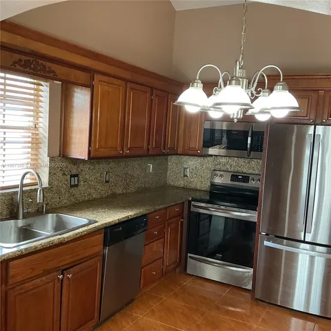 a kitchen with stainless steel appliances sink stove microwave and cabinets
