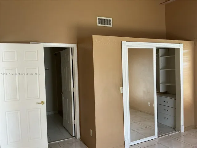 an empty room with windows and closet