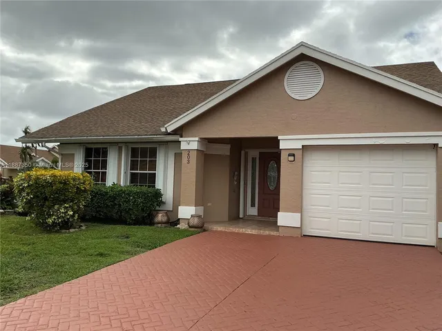 a front view of a house with a garden and yard