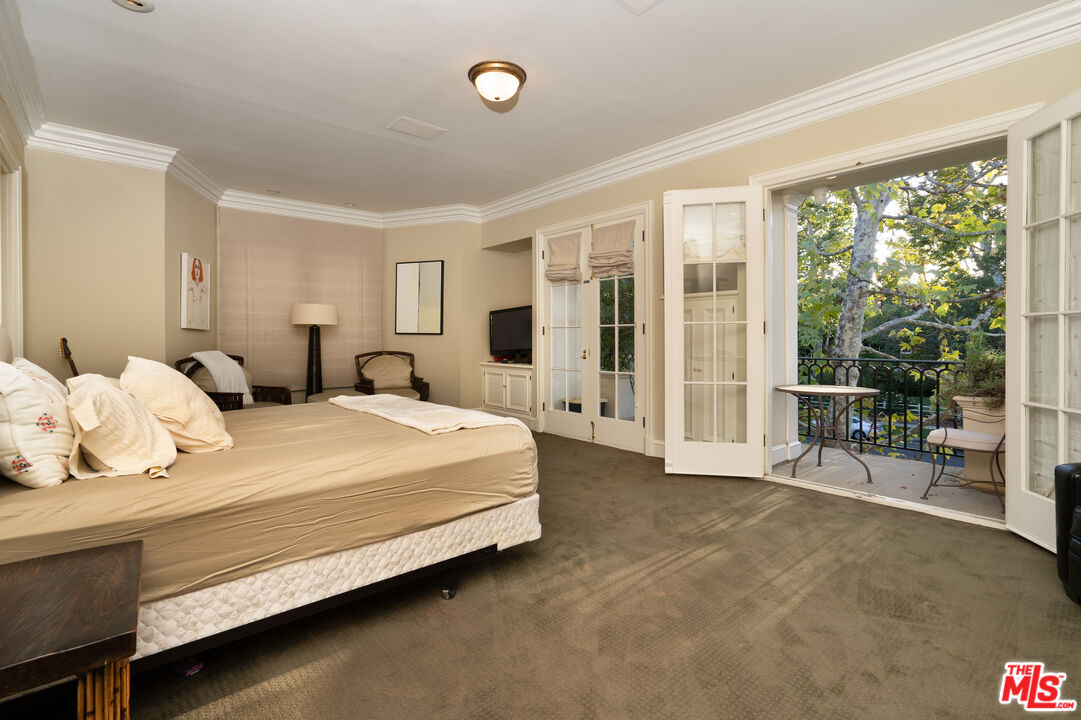 722 North Elm Drive Beverly Hills, CA 90210 - Photo 27 of 51 a bedroom with a large bed and a large window