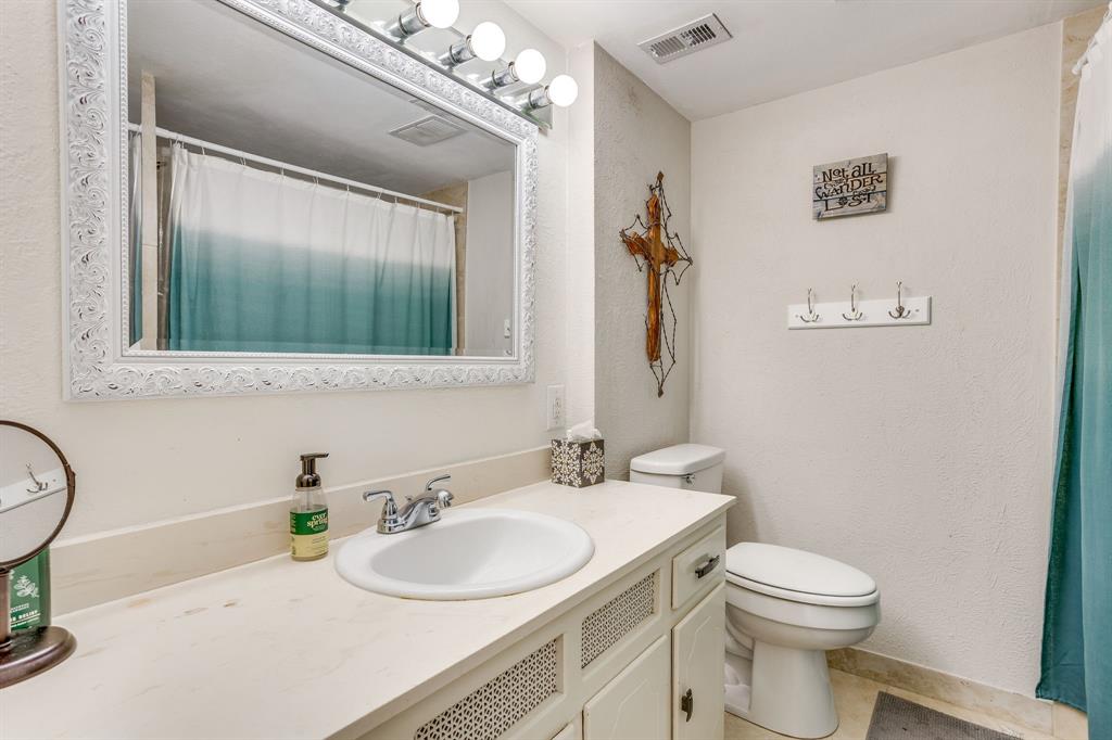 4102 Ridglea Country Club Drive, Unit 1503 Fort Worth, TX 76126 - Photo 7 of 21 Bathroom vanity with a single basin sink, chrome faucet, and a large framed mirror with overhead vanity lighting