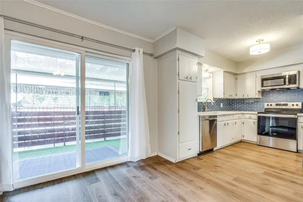 a kitchen with granite countertop a stove a sink and a refrigerator