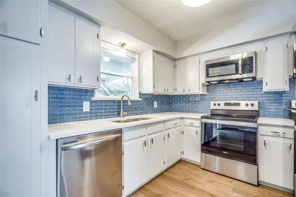 a kitchen with a sink stove and microwave