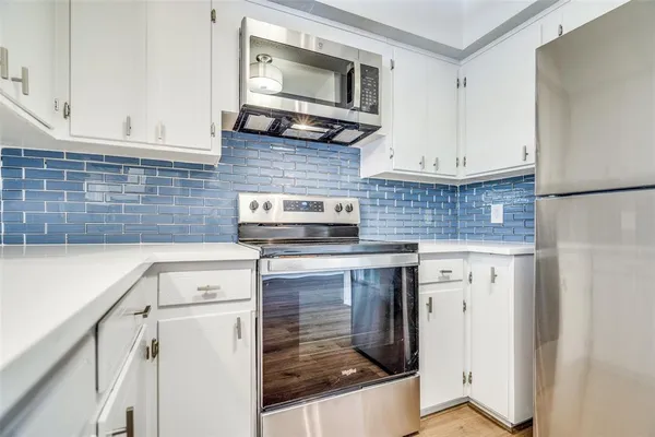 a kitchen with stainless steel appliances granite countertop a stove a sink and a microwave
