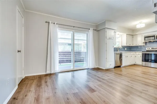 a view of kitchen with wooden floor electronic appliances and window