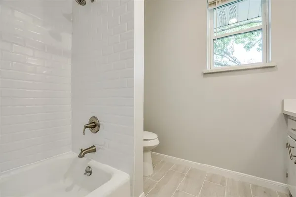 a bath tub sitting next to a white sink and a toilet