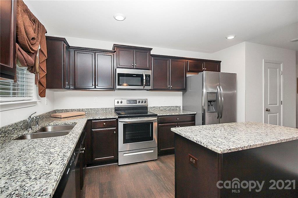 8036 Starnes Randall Road Charlotte, NC 28215 - Photo 11 of 45 a kitchen with a stove a sink and a refrigerator