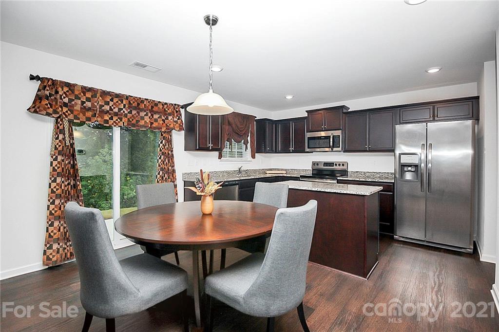 8036 Starnes Randall Road Charlotte, NC 28215 - Photo 15 of 45 a kitchen with kitchen island a dining table and chairs